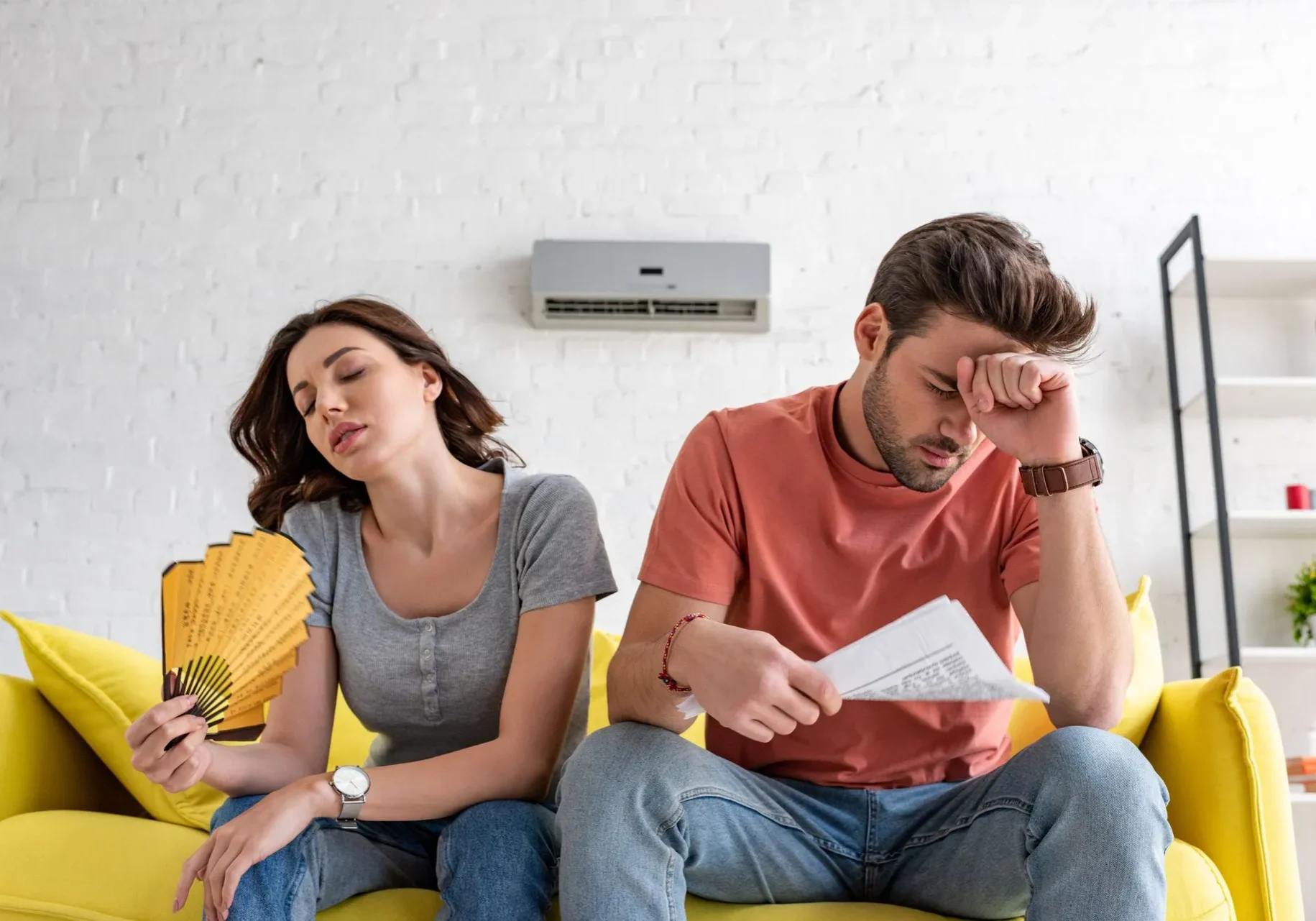man-with-newspaper-and-woman-with-hand-fan-sitting-2022-12-16-17-56-42-utc-1920w